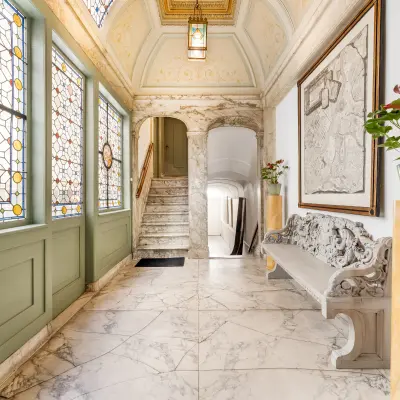 Elegant entrance space with marble flooring and ornate stained glass windows at office to rent on Keizersgracht 261, Amsterdam Canal Belt.