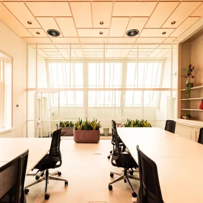 Bright office space with large windows, furnished with desks and chairs, perfect for workspace rental at Keizersgracht 264, Amsterdam Canal Belt.