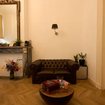 Charming office space at Keizersgracht 391A with a classic leather couch, a decorative fireplace, and ambient lighting, ideal for relaxing meetings in the Amsterdam Canal Belt.