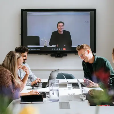 A vibrant office space in Amsterdam's Canal Belt at Keizersgracht 62-64, where professionals engage in a lively video conference, exemplifying an ideal office space rental.
