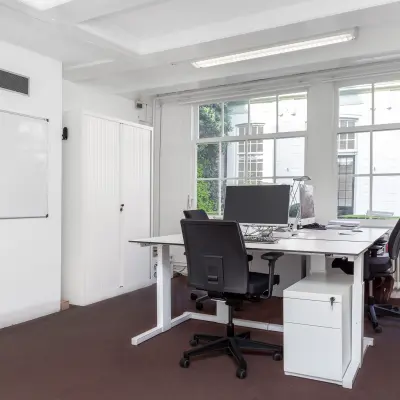 Bright office space with large windows, furnished with desks and chairs, ideal for office space rental at Keizersgracht 62-64 in Amsterdam Canal Belt.