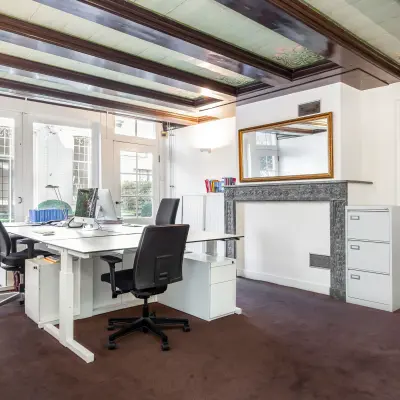 Bright office space with desks, chairs, and a view of the garden, suitable for rent office space at Keizersgracht 62-64, Amsterdam Canal Belt.