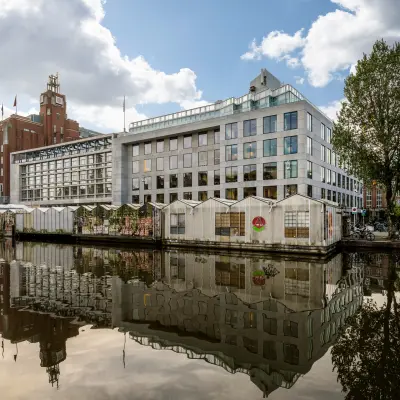 Exterior view of an office building at Singel 542, in Amsterdam Canal Belt, reflecting in the canal, ideal for rent office space seekers.