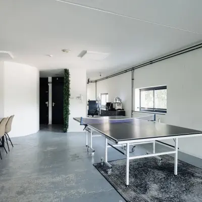 Spacious office area on Weesperstraat 394-396, Amsterdam Canal Belt, featuring a ping pong table and conference table, ideal for office space rental.
