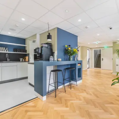 Bright, furnished office space available to rent at Herengracht 471, in Amsterdam Center, featuring a modern pantry area and stylish seating for informal meetings or breaks.