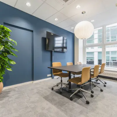 Modern office space at Herengracht 471, Amsterdam Center with a conference table, chairs, and a large screen, perfect for office space rental.