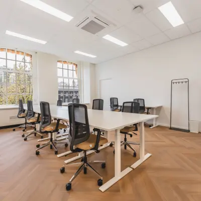 Bright and spacious office space rental at Herengracht 471, Amsterdam Center, featuring modern chairs and tables arranged for collaborative work.