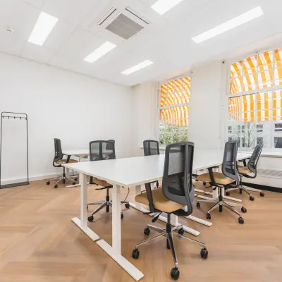 Bright office with modern desks and chairs at Herengracht 471, Amsterdam Center, ideal for office space rental.