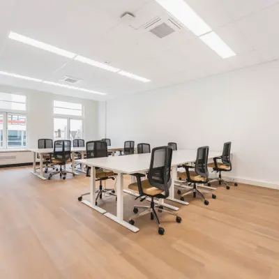 Bright office space with several desks and chairs arranged for workspace rental at Herengracht 471, Amsterdam Center.