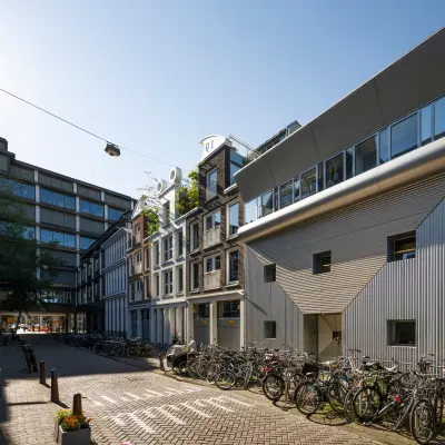 Exterior view of office buildings at Kerkstraat 204, Amsterdam Center, featuring a modern facade and bicycles parked outside. Ideal for office space rental opportunities.