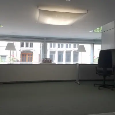 Bright office space at Kerkstraat 204, Amsterdam Center, ideal for rent with large windows and modern furnishings, offering a practical office space rental opportunity.