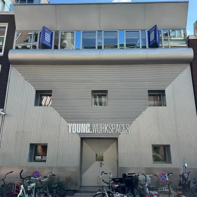 Exterior view of an office building for rent at Kerkstraat 204, Amsterdam Center, featuring a modern facade and bicycles parked outside.