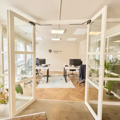 Bright office space at Kleine Gartmanplantsoen 21, Amsterdam Center, featuring glass doors and modern furnishings. Ideal for office space rental with plants enhancing the workspace ambiance.