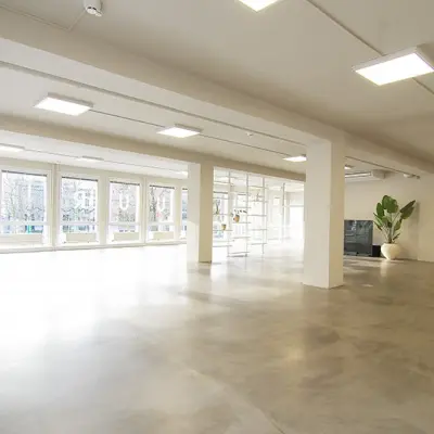 Spacious and well-lit office space available for rent at Kleine Gartmanplantsoen 21, Amsterdam Center, with large windows and modern design.