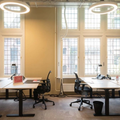 Bright office space with large windows and modern desks at Nieuwezijds Voorburgwal 104-108, Amsterdam Center, perfect for those seeking an office space rental.