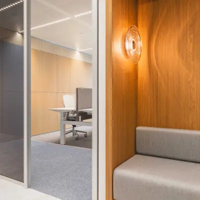 Modern office space with sleek wooden paneling and a comfortable seating area at Piet Heinkade 55, Amsterdam Center. Ideal for those looking for office space rental.