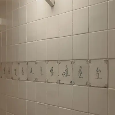 Tiled wall with decorative illustrations at Prins Hendrikkade 14, Amsterdam Center. Ideal for office space rental.