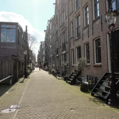 Exterior view of the office location at Prinseneiland 23A, Amsterdam Center, showcasing a charming canal-side street ideal for an office space rental.