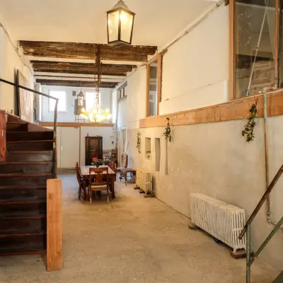 Interior view of a rustic office space at Prinseneiland 23A, with a wooden table and chairs under warm lighting, available for rent in Amsterdam Center.