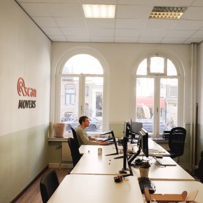 Office space at Raadhuisstraat 15, Amsterdam Center, featuring a furnished workspace with a person working at a desk, suitable for rent office space or office to rent needs.