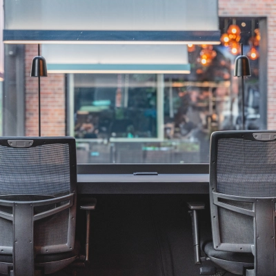 Modern office space at Raamplein 1, Amsterdam Center, featuring furnished workspaces ideal for office space rental with two ergonomic chairs and a large window view.
