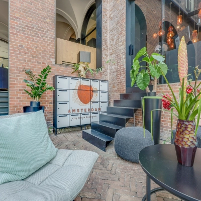 Inviting office space for rent in Amsterdam Center at Raamplein 1, featuring stylish furnishings with comfortable seating and decorative plants.