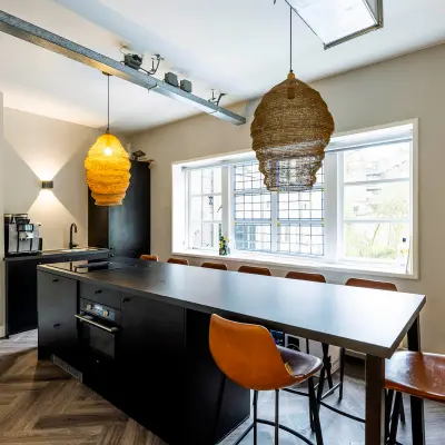Modern office kitchen area with a central island and seating at Rapenburgerstraat 173, ideal for rent office space in Amsterdam Center.