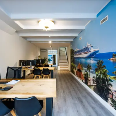 Bright office space rental at Rokin 105 105 in Amsterdam Center featuring desks, chairs, and a tropical mural, ideal to rent office space.