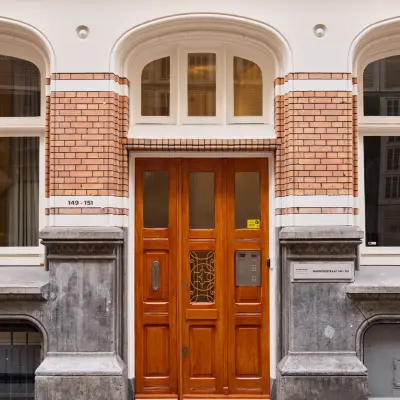 Elegant exterior view of an office building entrance at Warmoesstraat 149-151, perfect for those seeking office space rental in Amsterdam Center.