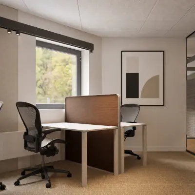 Bright Amsterdam office space with two sleek desks and modern chairs, ideal for anyone wishing to rent office space. Natural light filters through the large window.