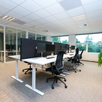 Modern office space rental at Overschiestraat 186 in Amsterdam De Schinkel, featuring furnished workspaces with desks and chairs in a bright interior.