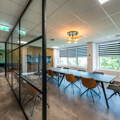 Bright office space with modern furnishings and large windows in Amsterdam De Schinkel, ideal for office space rental.