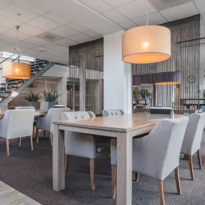 Modern office space rental with furnished workspaces at Daalwijkdreef 47 in Amsterdam Duivendrecht, featuring stylish seating and ambient lighting.