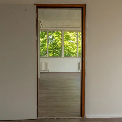 Unfurnished office space with wooden flooring and large windows at James Wattstraat 71, ideal for rent office space in Amsterdam East.