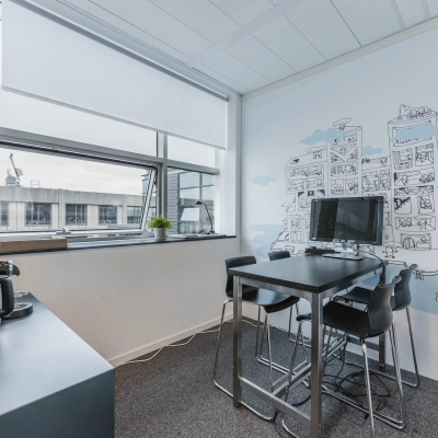 Bright office space at Piet Heinkade 95B, Amsterdam East, featuring modern furnishings and artwork. Ideal for rent office space with ample light and sleek furniture.
