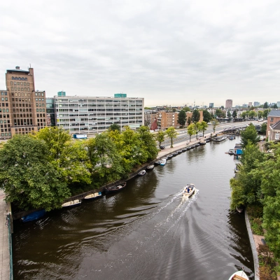 View of Rhijnspoorplein 10-38 in Amsterdam East, showcasing nearby waterways and urban surroundings, ideal for office space rental.
