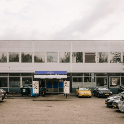 Exterior view of office building at Anthony Fokkerweg 3, Amsterdam New-West, surrounded by a parking area. Ideal for office space rental.