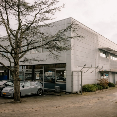 Exterior view of an office building available for rent at Anthony Fokkerweg 3, Amsterdam New-West, showing parking spaces in front.