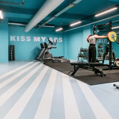 Gym area at Jan van Galenstraat 335, Amsterdam New-West, with equipment and people exercising.