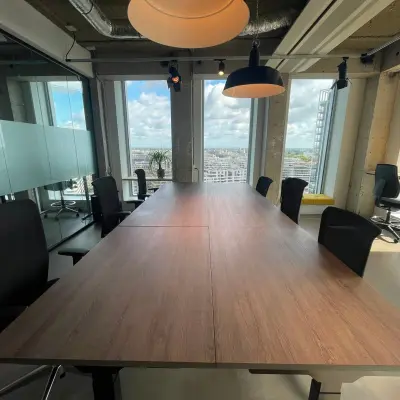 Spacious office for rent at Overhoeksplein 1 in Amsterdam North, featuring a modern conference room with large windows and views of the city.