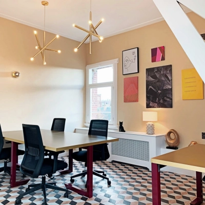 Bright office space rental with modern lighting, geometric flooring, and contemporary art on the walls, available in Amsterdam Old South at Emmalaan 7-9.