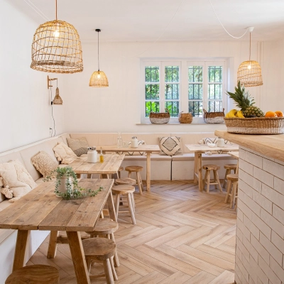 A cozy office to rent in Amsterdam Old South with wooden tables, cushioned benches, and natural light through large windows, perfect for work or meetings. Ideal for office space rental.
