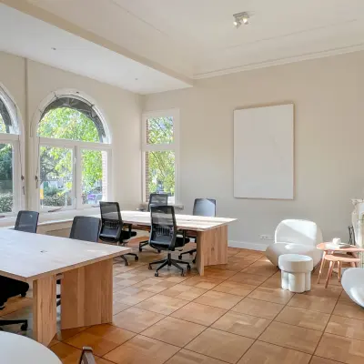 Bright office space with natural light, featuring multiple desks and comfortable seating at Emmalaan 7-9, Amsterdam Old South. Ideal for office space rental.
