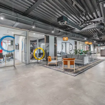 Stylish office space for rent at Olympisch Stadion 24-28, Amsterdam Old South, featuring modern furnishings, seating areas, and meeting rooms with colorful accents.