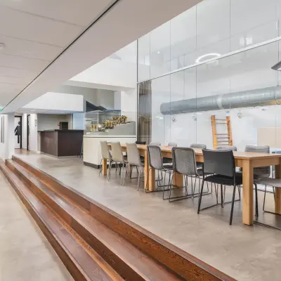 Spacious modern office with long meeting table and seating, featuring sleek design and ample lighting at Olympisch Stadion 24-28, perfect for office space rental in Amsterdam Old South.