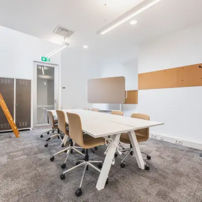 Furnished office space for rent at Olympisch Stadion 24-28, Amsterdam Old South, featuring a modern meeting area with conference table and chairs.