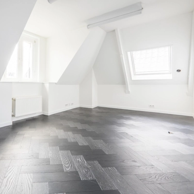 Bright, empty interior office space with sloped ceilings and wooden flooring at Sophialaan 21, ideal for office space rental in Amsterdam Old South.