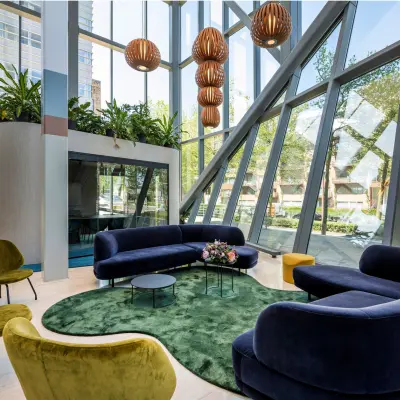 Bright office lounge area at David Ricardostraat 1 in Amsterdam Riekerpolder, featuring modern seating and large windows, ideal for office space rental.