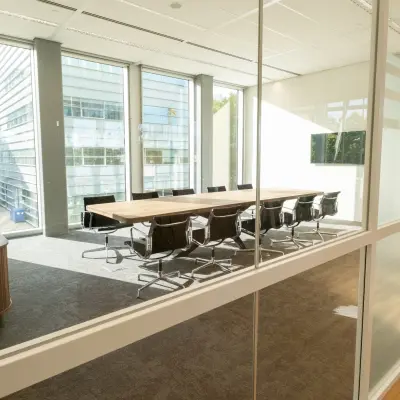 Bright conference room at David Ricardostraat 1 in Amsterdam Riekerpolder with large windows, modern table, and chairs, available for rent office space.