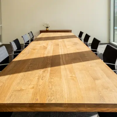 Spacious conference room with a long wooden table and modern chairs, ideal for office space rental in Amsterdam Riekerpolder.